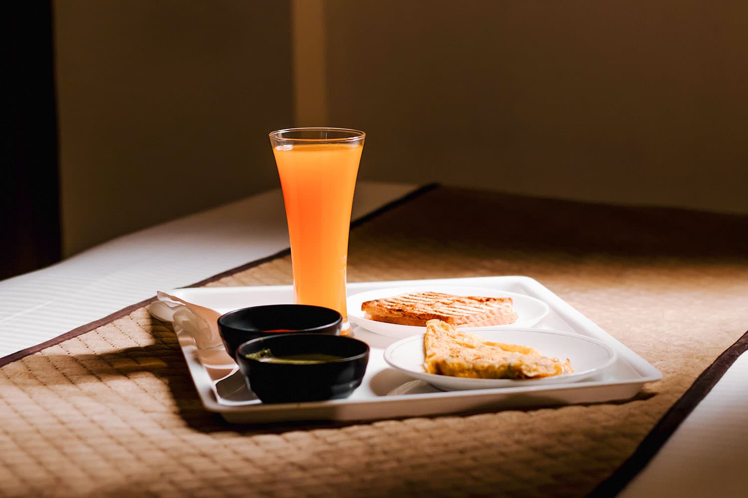 Breakfast tray on a quilted bed runner in morning light